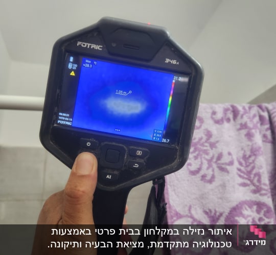 מד חום תרמי מציג נתונים על מסך, יד מחזיקה את המכשיר